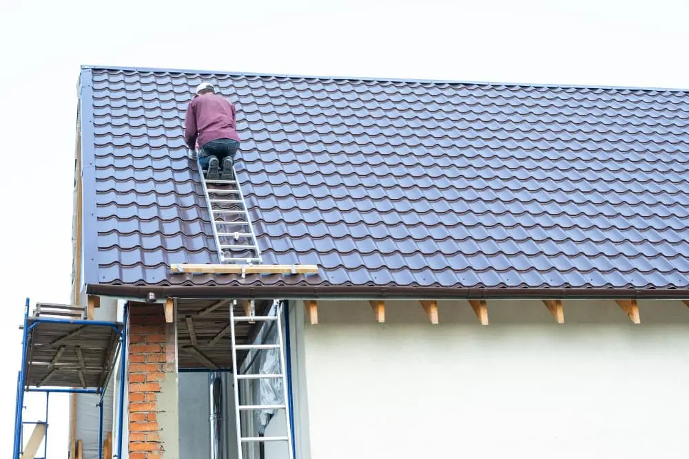 travaille sur le toit de la maison